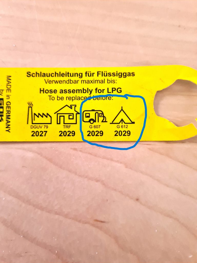 Gelbes Kennzeichnungsschild von einem Gasschlauch